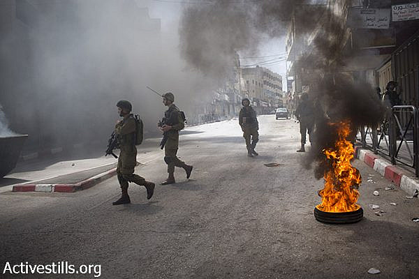 Israeli soldiers walk during clashes in the West Bank city of Hebron, after the Israeli army raided the city in the last days, June 16, 2014. (Oren Ziv/Activestills.org)