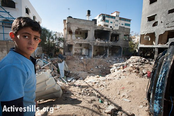 A child stands  amid the rubble of the Al Dalu family home, Gaza City, December 3, 2012. Ten members of the Al Dalu family were killed, as well as two neighbors, by an Israeli air strike on their three-story home on November 18, 2012. Four of those killed were children, and four were women.