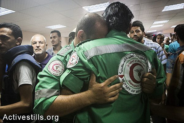 Medics at the Al-Shifa hospital mourn their colleague targeted and killed in Shejaiya neighbourhood earlier today, July 20, 2014. (Anne Paq/Activestills.org)