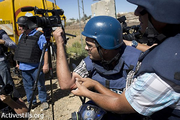 A member of the media holds his arm after being injured from a live bullet while covering Palestinian clashes with Israeli army, following a protest supporters by Hamas  against the Israeli attack on Gaza,on July 25, 2014, in the DCO checkpoint near Ramallah, West Bank.