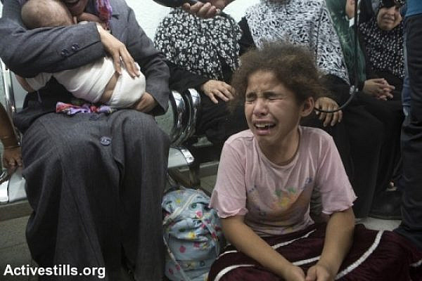 A Palestinian girl cries after an Israeli attack on Beit Hanoun elementary schools mourn in Kamal Edwan Hospital, Jabalyia, Gaza Strip, July 24. The school was being used as a shelter by 800 people. The attack killed at least 17 and injured more than 200 of the displaced civilians. Israeli attacks have killed 788 Palestinians and injured around 5,000 in the current offensive, most of them civilians. (photo: Anne Paq/Activestills)