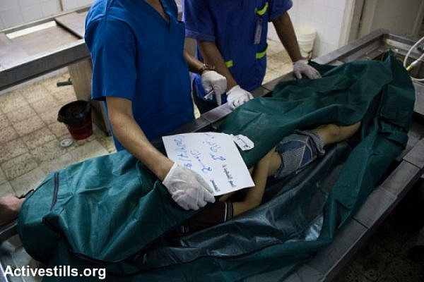 The bodies of Palestinians lie in the Al Shifa Hospital morgue in Gaza City following an attack on an UNRWA school in Jabaliya, July 30, 2014 (photo: Activestills)