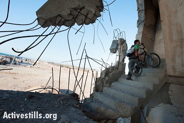 A Palestinian child plays among the ruins of buildings destroyed by Israeli air strikes in the 2008-2009 war known as Operation Cast Lead, July 4, 2012. (Photo by RyanRodrick Beiler/Activestills.org)