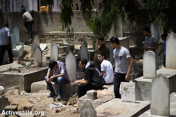 Palestinians mourn the death of Ibrahim Nabil Hamada, 23, who was killed during an Israeli attack, Al Shaja'ia cemetery, Gaza City, July 12, 2014. (Photo: Basel Yazouri/Activestills.org)