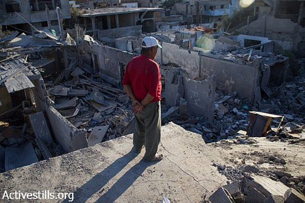 Palestinian man look toward the ruins of Beit Hanoun, North Gaza Strip, August 11, 2014.  According to OCHA, during the current attack, 16,800 Homes in the Gaza Strip have been destroyed or severely damaged and 370,000 displaced People hosted at UNRWA, government shelters and with host families. (Basel Yazouri/Activestills.org)
