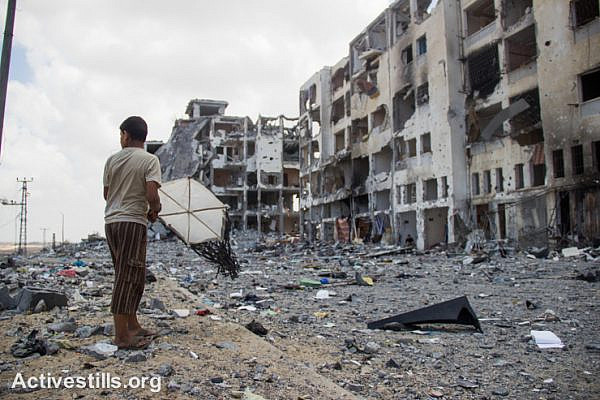 A Palestinian child with a kite stands in front of the destroyed Al Nada towers in Beit Hanoun, northern Gaza Strip. The towers had 90 flats.