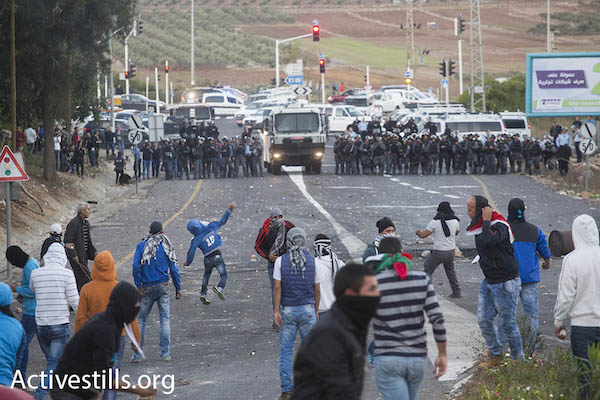 Arab youth clash with Israeli riot police in Kafr Kanna, Israel, November 8, 2014. The protests took place after an Arab man from the village was shot and killed by Israeli policemen. (Photo: Oren Ziv/Activestills.org)