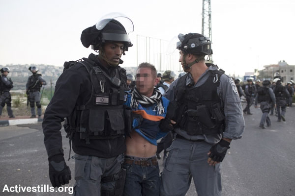 Israeli police arrest an Arab youth during clashes in Kfar Kanna, November 8, 2014. Clashes broke after police shot and killed 22-year-old Kheir Hamdan while he was attempting to flee after striking a police van with a knife. (Photo by Oren Ziv/Activestills.org)