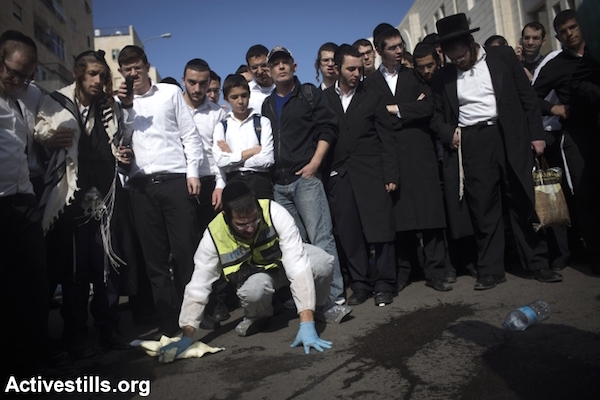 Israeli emergency services volunteers remove blood, according to Jewish tradition, from the scene of an attack by two Palestinians against Jewish worshippers at a synagogue in the ultra-Orthodox neighborhood of Har Nof in West Jerusalem, November 18, 2014. Two Palestinians armed with guns, a meat cleaver and knives burst into a Jerusalem synagogue and killed four Israelis before being shot dead by Israeli forces. (Photo by Oren Ziv/Activestills.org)