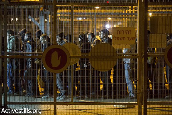 Palestinian laborers arrive at the first of eight metal carousels they must pass through in the Sha’ar Ephraim checkpoint separating the West Bank and Israel, December 22, 2014. (Oren Ziv/Activestills.org)
