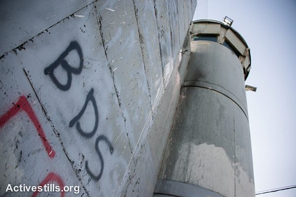 Graffiti on the Israeli separation wall dividing the West Bank town of Bethlehem promotes the BDS movement, June 17, 2014. (Ryan Rodrick Beiler)