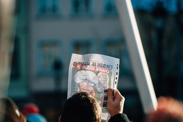 People holding Charlie Hebdo cover with Mohammed cartoon during a unity rally (Marche Republicaine), in which 50000 people paid tribute following the three-day killing spree in Paris, January 11, 2015. (Photo by Shutterstock.com/Hadrian)