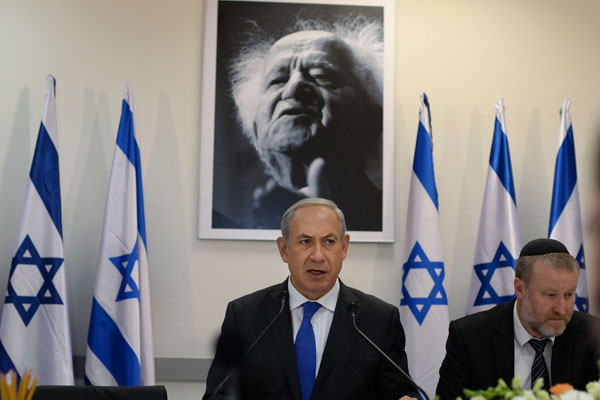Prime Minister Benjamin Netanyahu stands in front of a portrait of Israel’s first prime minister, David Ben-Gurion. (Kobi Gideon/GPO)