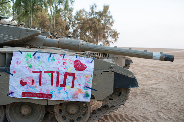 A ‘thank you’ sign sent by Israeli children hangs on an IDF tank. (Ran Zisovitch / Shutterstock.com)