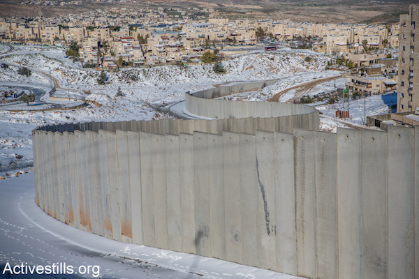 Snow around the separation wall that surrounds the Shuafat Refugee Camp in East Jerusalem, February 20, 2015. (Photo by Yotam Ronen/Activestills.org)