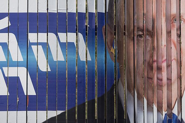 A campaign billboard for Netanyahu’s Likud switches to a billboard for Isaac Herzog’s Zionist Camp. (Oren Ziv/Activestills.org)