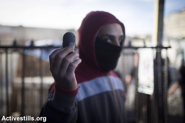 A Palestinian youth displays a black sponge-tipped bullet shot by Israeli police near the Shuafat Refugee Camp in East Jerusalem, November 7, 2014. (Photo by Oren Ziv/Activestills.org)