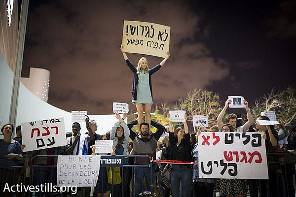 Israeli activists protest a proposed policy of giving African asylum seekers in Israel the option of indefinite imprisonment or ‘self-deportation’ to a third country, Tel Aviv, May 2, 2015. (Photo by Oren Ziv/Activestills.org)