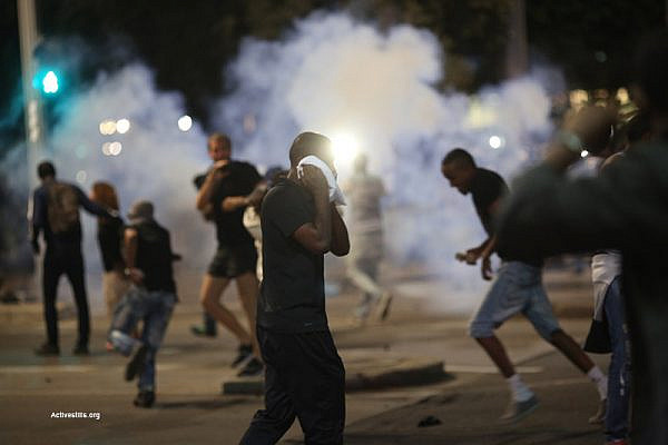Protesters scatter as police use stun grenades to disperse a protest by Israeli of Ethiopian descent demonstrating against police violence, May 3, 2015. (Activestills.org)