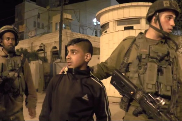 Israeli soldiers detaining 14-year-old Palestinian boy Maher Abu Haya in Hebron, April 6, 2015. (B'Tselem screenshot)