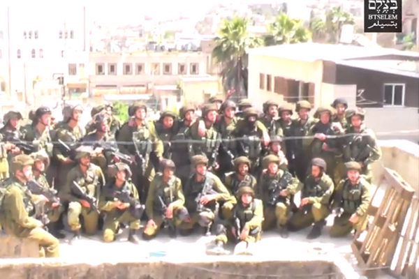Soldiers pose for a group photo on the roof of the Abu Haya family home in Hebron. (screenshot: B'Tselem)