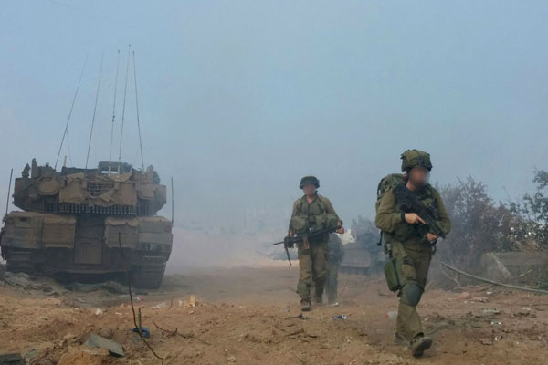 An Israeli soldiers walk next to a tank in the Gaza Strip during 2014’s Operation Protective Edge. (Courtesy of Breaking the Silence)