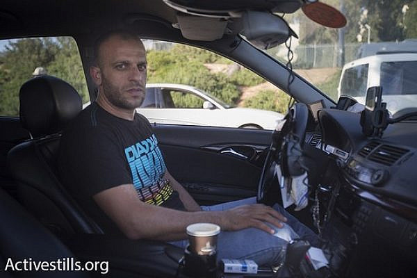 Thair Reg'i, who exposed Cinema City's discriminatory policies toward Arab cab drivers, is seen inside his taxi. (photo: Activestills.org)