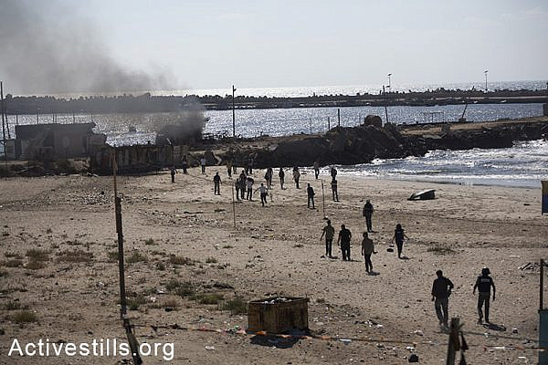 Paramedics, journalists and bystanders run toward the the scene where four Palestinian children were killed by Israeli military shelling at a Gaza City beach, July 16, 2014. (photo: Activestills)