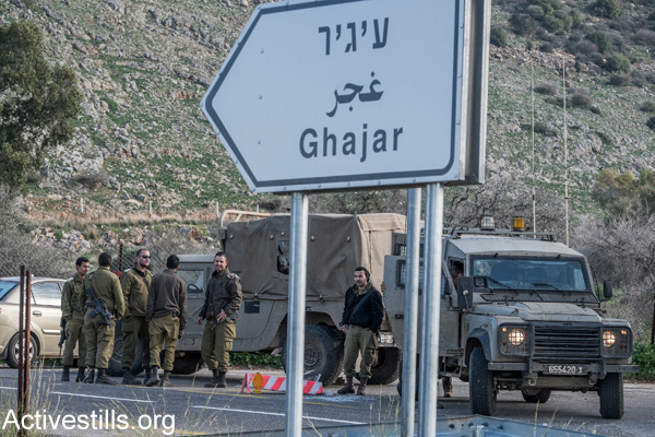Israeli soldiers stand near the entrance to the divided village of Ghajar on the Lebanese-Israeli border, January 19, 2015. (Yotam Ronen/Activestills.org)