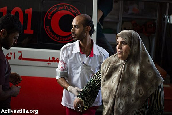 Palestinians injured in Israeli air strikes on the Gaza Strip arrive at Al Shifa Hospital in Gaza City on the night of July 8, 2014. On the first day of the Israeli offensive 23 Palestinians were killed, including 7 children, and about 320 were injured. (Basel Yazouri/Activestills.org)