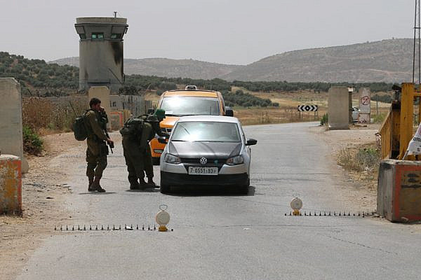 Israeli soldiers check cars at a checkpoint in the West Bank, May 27, 2015. (Activestills.org)