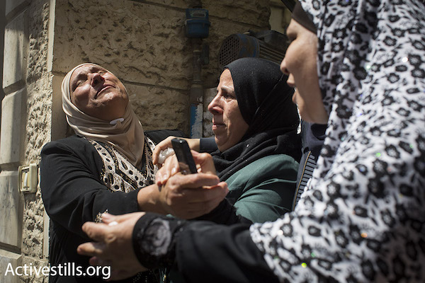 An aunt of Muhammad Abu Latifa cries at his funeral in Qalandia Refugee Camp in between Ramallah and Jerusalem, July 27, 2015. Abu Latifa was killed while fleeing Israeli special police commandos during an arrest raid on his home early that morning. (Oren Ziv/Activestills.org)