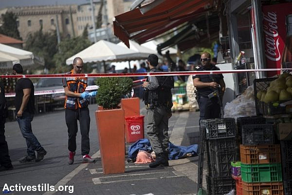 The body of a Palestinian teen is seen on the street near damascus gate, in Jerusalem, October 10, 2015. The teen, later identified as Ishaq Badran, 16, from Kafr Aqab, was shot and killed by the Israeli police after carrying out an alleged stabbing attack in the area. The death of the suspected attacker brings the total number of Palestinians killed since Oct. 1 to 10, while four Israelis, including two settlers, have been killed in the same time period. (photo: Anne Paq/Activestills.org)