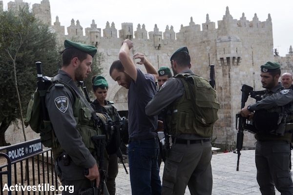 Israeli Border Police search a Palestinian man near Damascus Gate in the Old City of Jerusalem, October 23, 2015. Many new checkpoints have been set up in East Jerusalem's Palestinian neighborhoods in the wake of a spate of stabbings in the city. Jerusalem, October 23, 2015. (Anne Paq/Activestills)