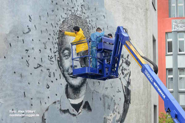 Yazan Halwani, joined by local students, working on the mural of Fares in Dortmund, Germany. (Photo by Alex Volkel)