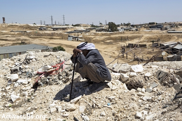 A man from the Zanoun family sits on the ruins of his house a few hours after it was demolished by the Israeli Land Administration, in the unrecognized Bedouin village of Wadi Al Na'am, Negev Desert, May 18, 2014. The family of seven people was living in the house demolished for being illegaly built. Wadi Al-Na’am is the largest unrecognized village in Israel, with about 13,000 inhabitants, most of its inhabitants are internally displaced. The village is not connected to electricity and its inhabitants are subjected to Israel's house demolition policy. (Keren Manor/Activestills)