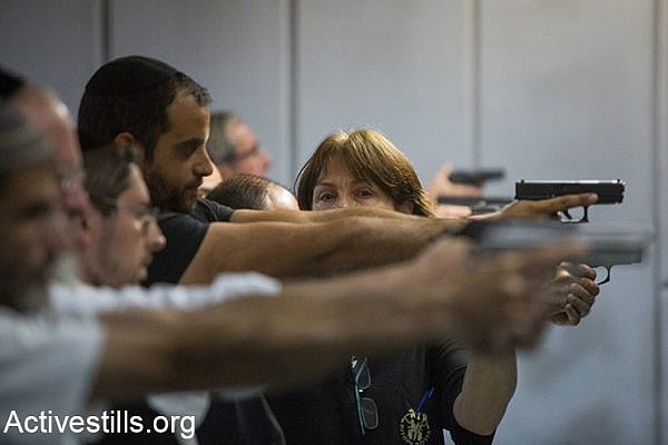 Israelis attend a shooting practice in a gun shop in Jerusalem on October 15, 2015. Arms shop's owners report a rise in demand for weapons and other self defence gear as violence continues around Jerusalem. (Activestills.org)