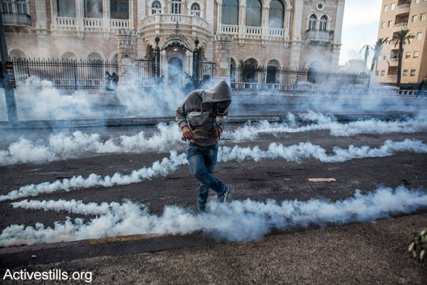 A Palestinian youth kicks a tear gas canister during clashes with the Israeli army in the West Bank city of Bethlehem, November 20, 2015. (photo: Activestills.org)