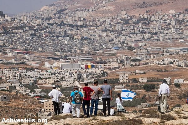 Israeli settlers attempt to establish a new outpost in response to the killing of two settlers the night before, near the settlement of Itamar, West Bank, October 2, 2015. (photo: Yotam Ronen/Activestills.org)