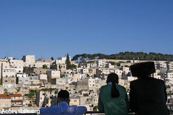 Orthodox Jews look out over the Palestinian village of Silwan in East Jerusalem. (Yotam Ronen/Activestills.org)