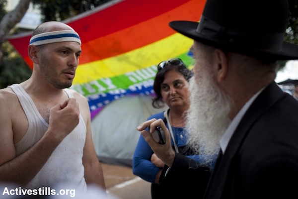An ultra-Orthodox Jewish man argues with a secular social justice protester in Tel Aviv, July 18, 2011. (Oren Ziv/Activestills.org)