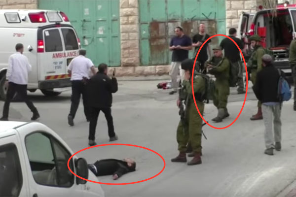 An IDF soldier is seen seconds before shooting a wounded Palestinian man in the head. (Screenshot/B’Tselem)