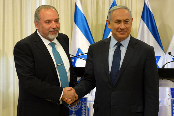 Prime Minister Benjamin Netanyahu and newly appointed defense minister Avigdor Liberman sign new coalition agreement, May 25, 2016. (Amos Ben Gershom/GPO)