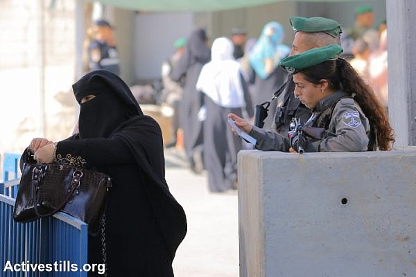 Palestinian women cross Qalandiya checkpoint, a main crossing point between Jerusalem and the West Bank city of Ramallah, as they head to Al-Aqsa Mosque for the first Friday prayer of the holy Muslim month of Ramadan. (photo: Ahmad al-Bazz/Activestills.org)