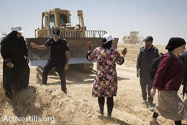 A Bedouin woman attempts to block a bulldozer during a march in the unrecognized village of Al-Araqib, Negev Desert, July 24, 2016. (photo: Oren Ziv/Activestills.org)