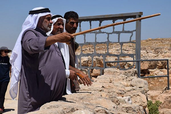 Palestinian residents of Susya point to caves and wells where they once lived and drank before the Israeli army evicted them from their village in order to turn it into an archeological site, Susya, South Hebron Hills, July 14, 2016. (Michael Schaeffer Omer-Man)