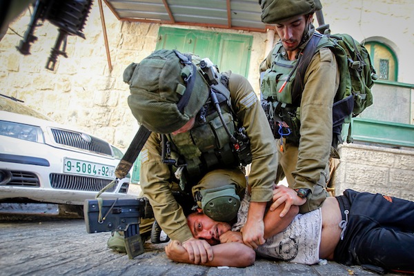Israeli soldiers detain a Palestinian man following a house raid in the West Bank city of Hebron September 20, 2016. (Wisam Hashlamoun/Flash90)