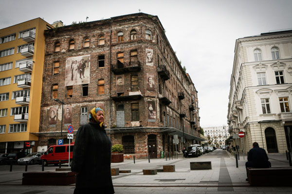 A Polish woman walks by Prozna Street in Warsaw, a part of the former Jewish quarter that escaped destruction during World War II. (Miriam Alster/FLASH90)