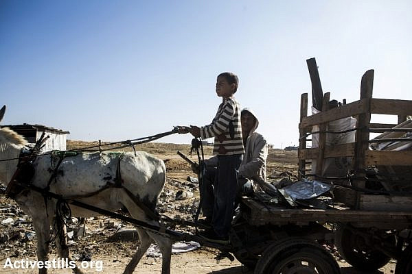 Palestinian children collect scrap metal and materials after Israel’s 2014 assault on the Gaza Strip, Beit Hanoun, Gaza Strip, November 9, 2014. (Anne Paq/Activestills.org)