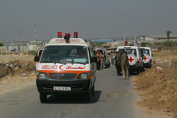 International Red Cross members try to secure an ambulance for ill Palestinians for transport to Israel as Israeli tanks stand watch,  northern Gaza near the Erez Crossing, June 19, 2007. (Ahmad Khateib/Flash90)